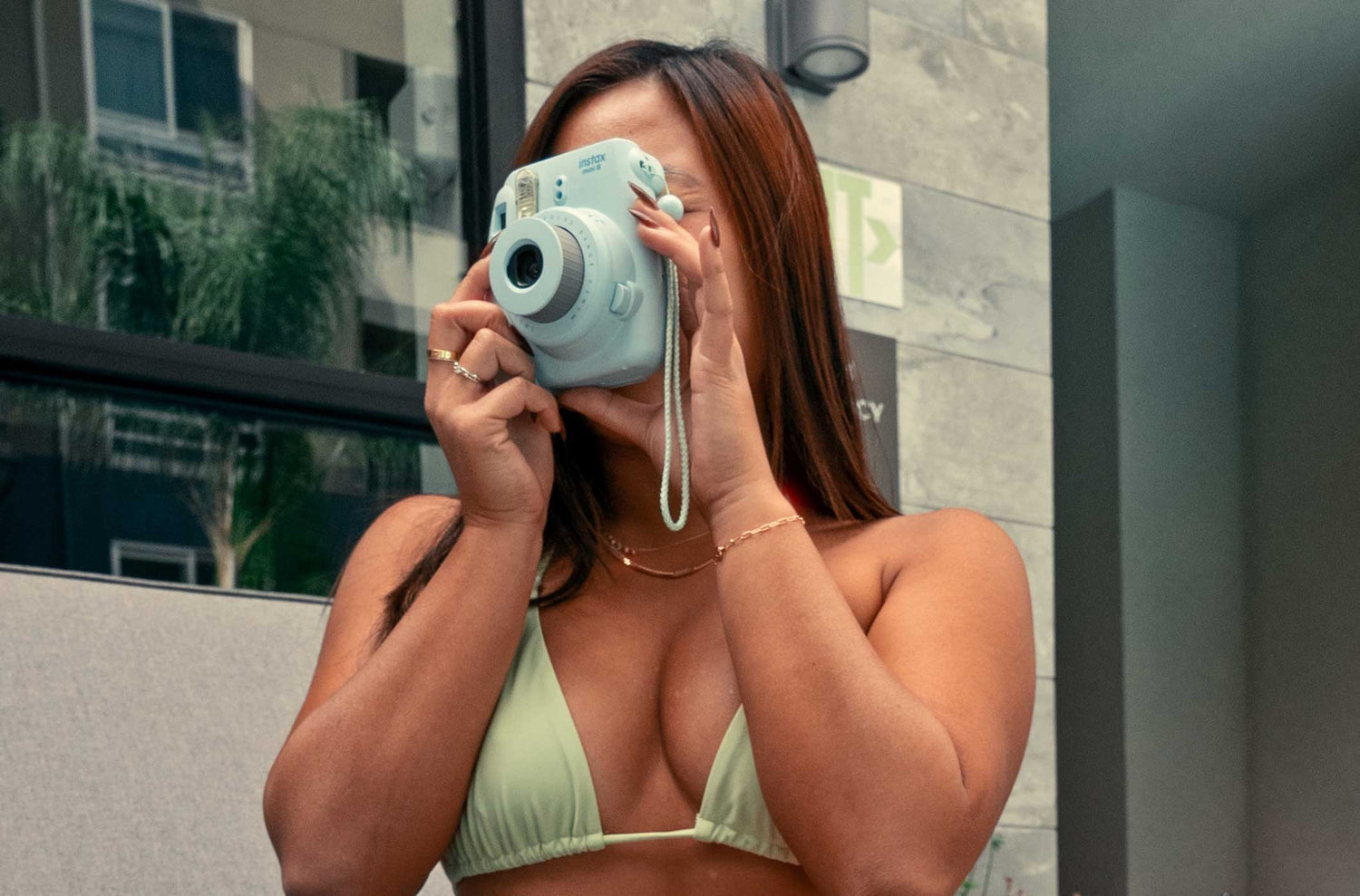 model taking a photo with polaroid camera